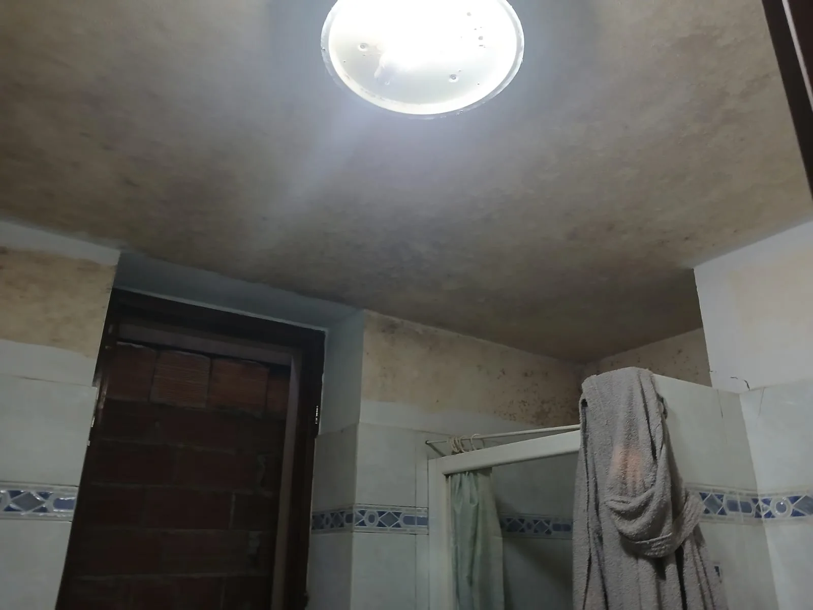 Bagno con doccia prima del risanamento edile del soffitto