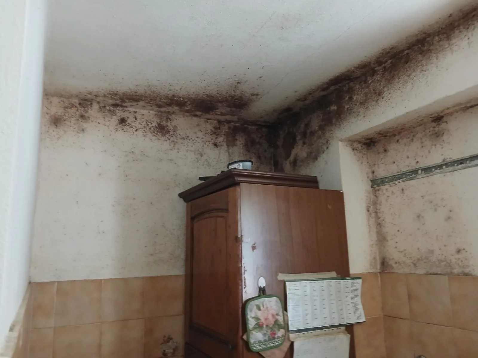 Cucina con armadio e termosifone prima del risanamento edile ADM